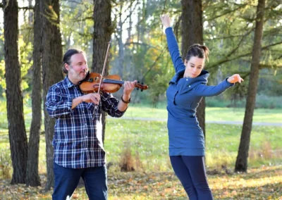 Mélissandre Tremblay-Bourassa en suspension lors d'un pas de gigue, accompagnée par Gabriel Girouard au violon en forêt.