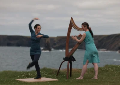 Rires et complicité entre la danseuse Mélissandre T-B et la harpiste Úna Ní Fhlannagáin durant une performance.