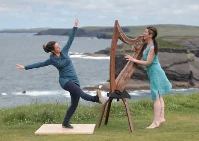Rires et complicité entre la danseuse Mélissandre T-B et la harpiste Úna Ní Fhlannagáin durant une performance.